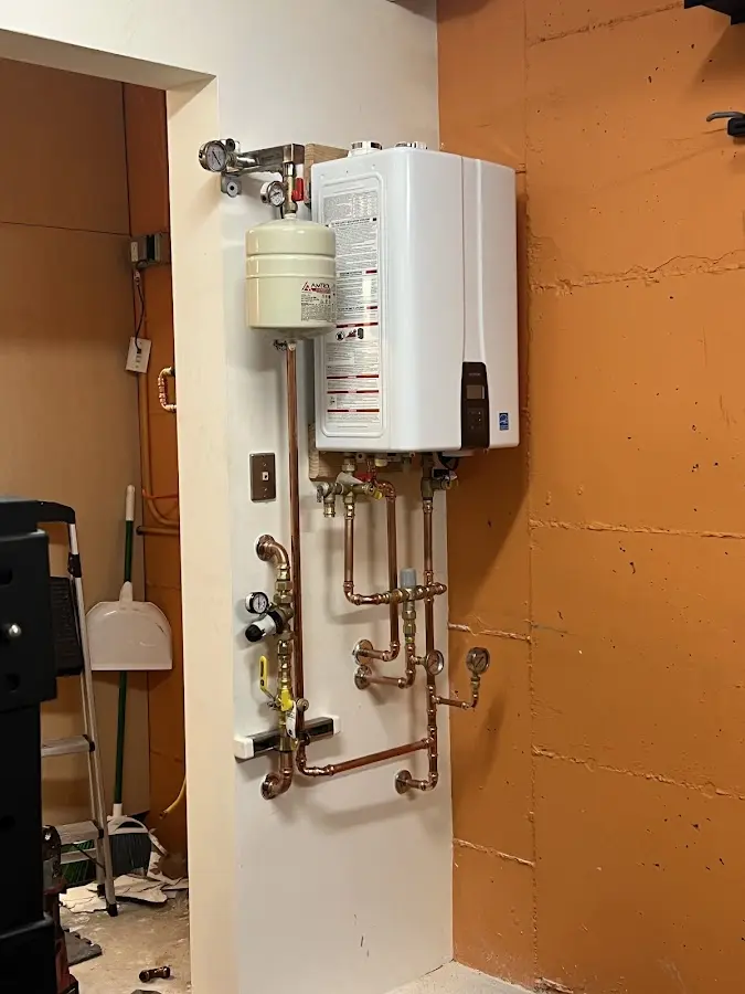 Plumbing technician inspecting water heater connections in Flagstaff